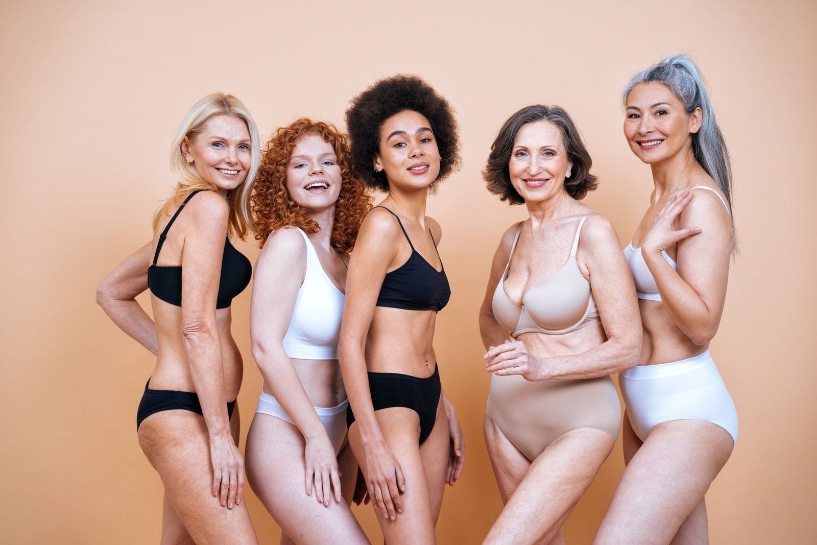 Five women of different ages, skin tones and body types, wearing a range of Voilà intimates styles, standing together.